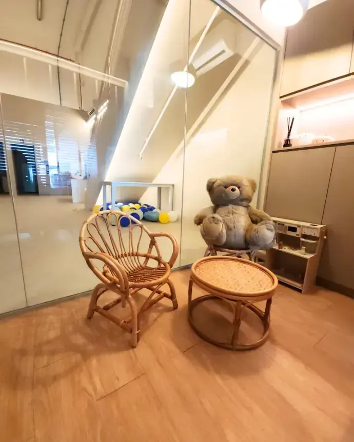 The playroom corner with rattan seating and a play kitchen